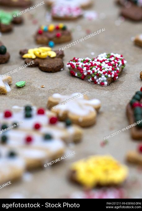 10 December 2020, Saxony-Anhalt, Magdeburg: A heart with colourful sugar balls lies on a tray next to other Christmas cookies