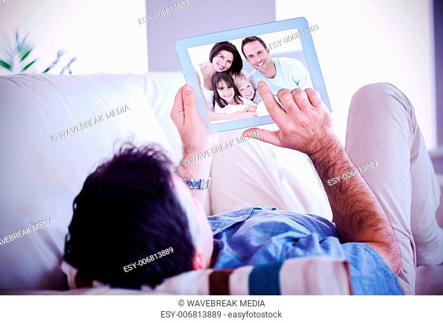 Composite image of portrait of a happy family sitting on the bed