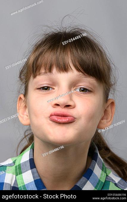 Portrait of a ten-year-old girl showing a kiss, European appearance, close-up