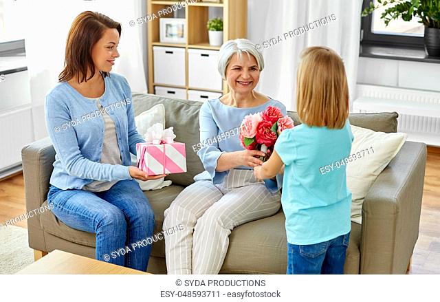 granddaughter giving flowers to grandmother