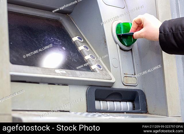 ILLUSTRATION - 05 December 2021, Berlin: A bank customer inserts her checking card into an ATM. Photo: Fernando Gutierrez-Juarez/dpa-Zentralbild/ZB