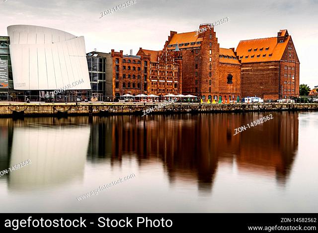 Stralsund, Germany - August 1, 2019: Scenic view of the harbour and the Ozeaneum aquarium in Stralsund. Long exposure view at sunrise with reflection on water