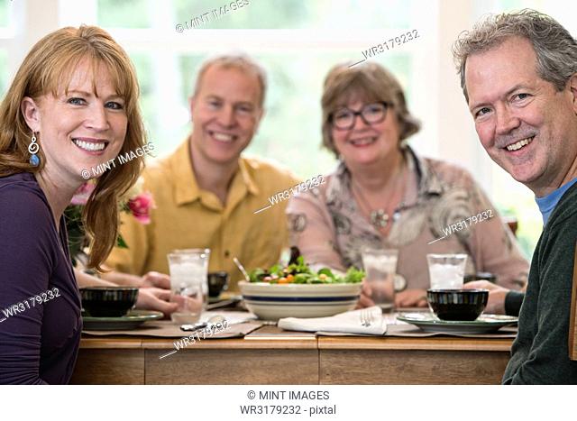 Two senior couples getting together for a dinner party
