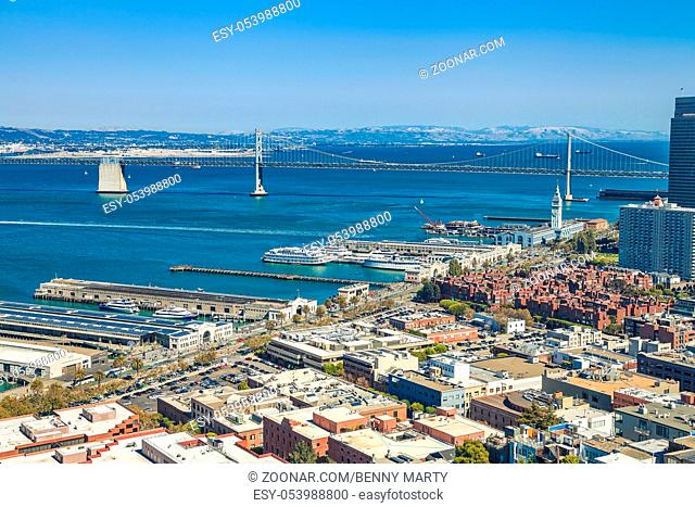 Aerial cityscape of San Francisco Embarcadero and Oakland Bridge from top of Coit Tower on sunny day on Telegraph Hill, California, United States
