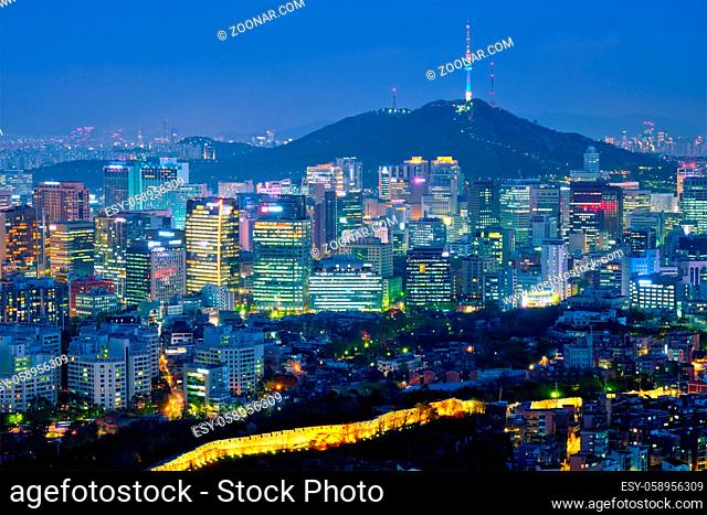 Seoul downtown cityscape illuminated with lights and Namsan Seoul Tower in the evening view from Inwang mountain. Seoul, South Korea
