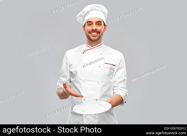happy smiling male chef holding empty plate