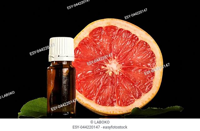 Liquid with a citrus aromafor for smoking an electronic cigarette, and piece of grapefruit isolated on black background