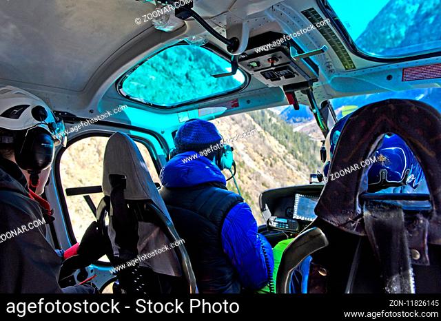 Pilot und Passagiere auf einem Transportflug im Helikopter Eurocopter AS 350B3 Ecureuil, Wallis, Schweiz / Pilot and passengers during a transport flight in the...