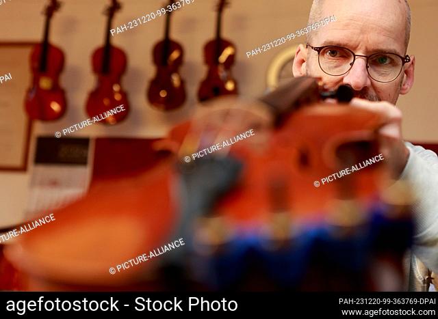 20 December 2023, Saxony-Anhalt, Wernigerode: Master violin maker Matthias Vorbrodt checks a violin. The master violin maker specializes in repairing stringed...