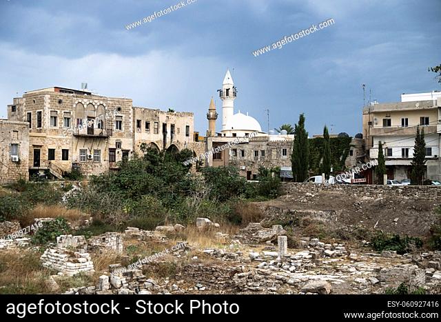 Old city with mosque and ruins with dark dramatic cloudscape in Tyre, Sour, Lebanon
