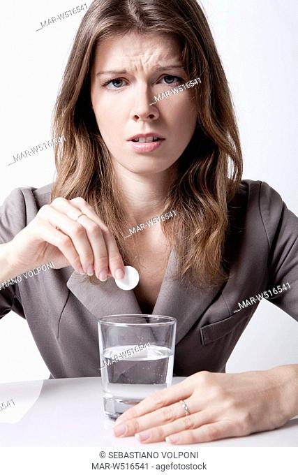 donna influenzata, bicchiere d'acqua con pastiglia effervescente