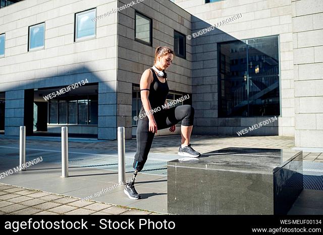 Sporty young woman with leg prosthesis in the city