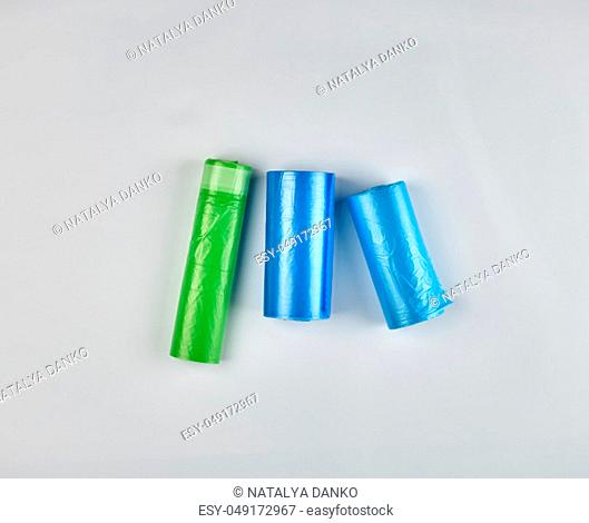 three rolled up rolls with plastic garbage bags on a white background