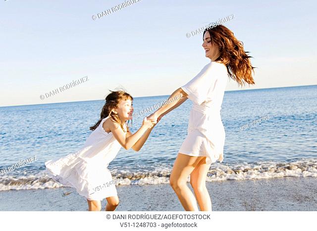 Mother and daughter having fun in the beach
