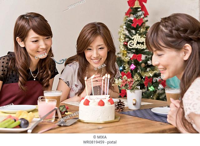Three Young Women Looking at Christmas Cake