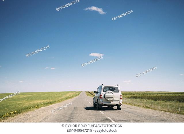 Gray SUV Car Mooving Along Road In Spring Summer Fields Landscape. Drive And Travel Concept
