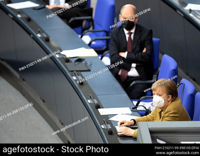 11 February 2021, Berlin: Olaf Scholz (l, SPD), Federal Minister of Finance, and Chancellor Angela Merkel (CDU) listen to the debate on the government statement...