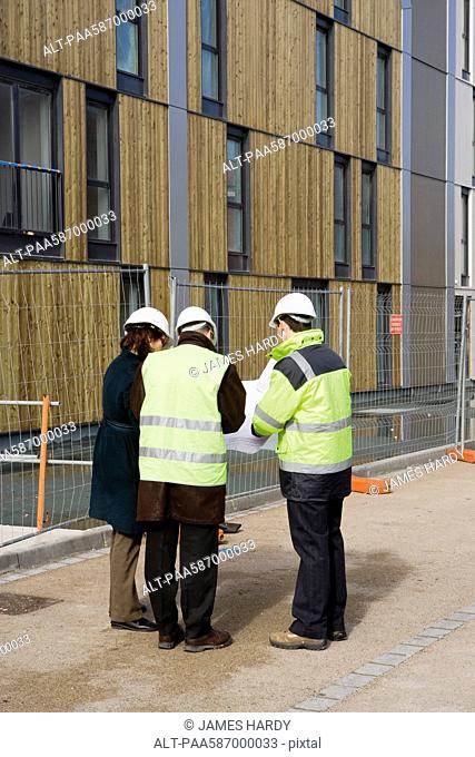 Building contractor and architects in discussion at construction site