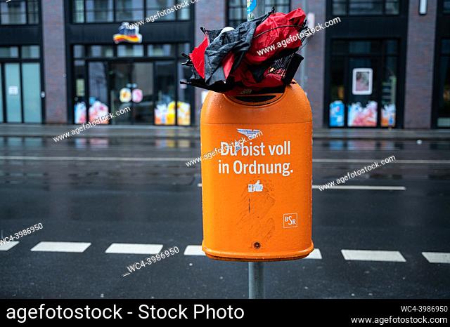 Berlin, Germany, Europe - A broken umbrella squeezed into an overflowing dustbin of the BSR with the lettering""Du bist voll in Ordnung""
