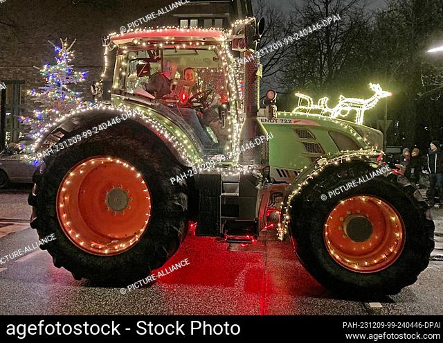 09 December 2023, Storman, Hamburg: Tractors decorated for Christmas driving along a road. Farmers from Eichede (Stormarn district) brought donations to the...