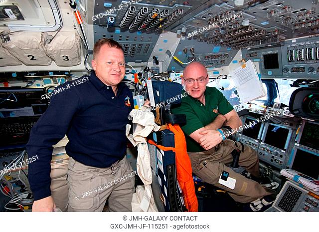 NASA astronauts Eric Boe (left), STS-133 pilot; and Scott Kelly, Expedition 26 commander, take a moment for a photo on the flight deck of space shuttle...