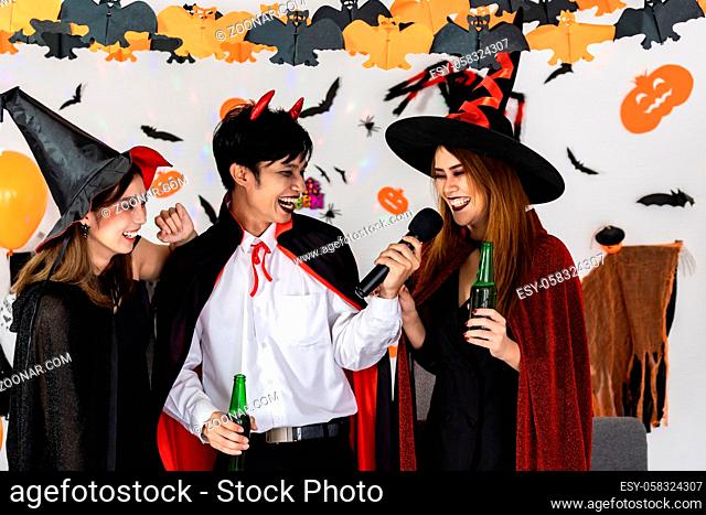 Portrait group of friends asian young adult people celebrate Halloween party carnival festive. They wear Halloween costume sing a song and cheers