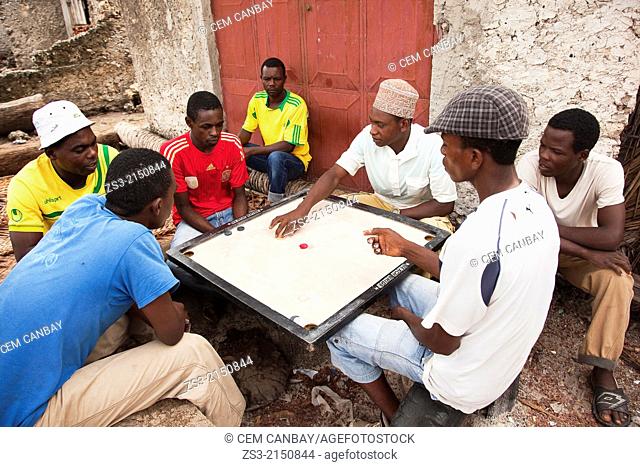 Muslim men playing Carrom, an old Indian game, in front of a house, Jambiani village, Zanzibar Island, Tanzania, East Africa