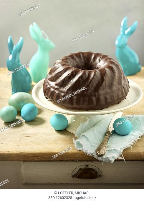 A Bundt cake with chocolate glaze and Easter decorations