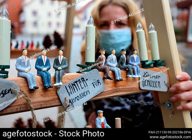 30 November 2021, Saxony-Anhalt, Wernigerode: Ilka Hoffmann-Woyde decorates a rung ladder in front of her shop. Hope and confidence are to be spread by the...