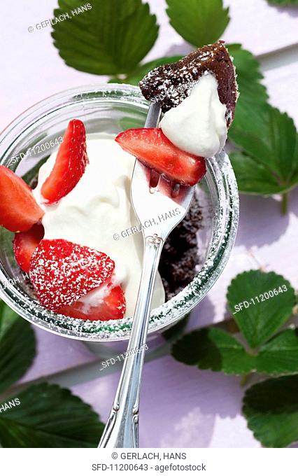 Chocolate pudding in a jar with strawberries and cream