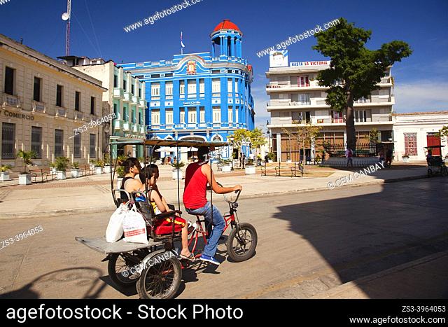Bici Taxi carrying people in front of the Santa Cecilia Convention Center-Centro de Convenciones at the historic center, Camagüey, Cuba, West Indies