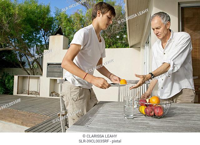 Father and son clearing table outdoors