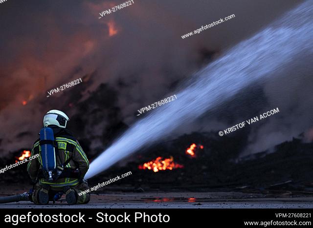 A fire fighter pictured at the site of IOK recycling and waste management company, in Beerse, Monday 28 March 2022. BELGA PHOTO KRISTOF VAN ACCOM