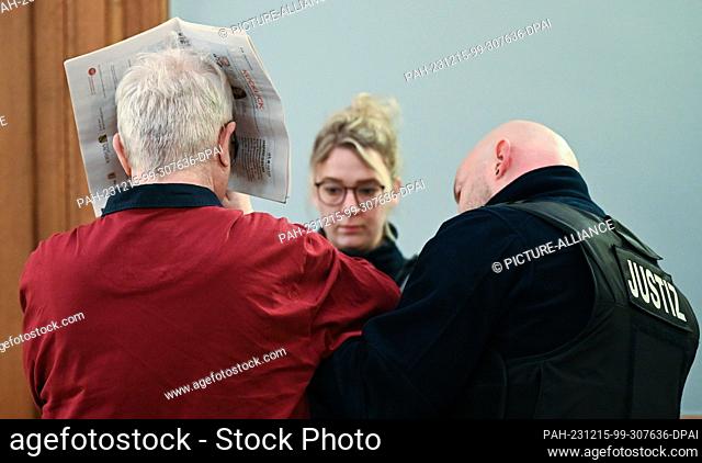 15 December 2023, Saxony, Leipzig: The defendant's handcuffs are removed before the trial begins. Six months after the brutal killing of a woman in Borna