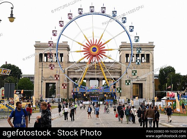 02 August 2020, Bavaria, Munich: A Ferris wheel stands on the Königsplatz in front of the Propyläen. Since the Wiesn is cancelled
