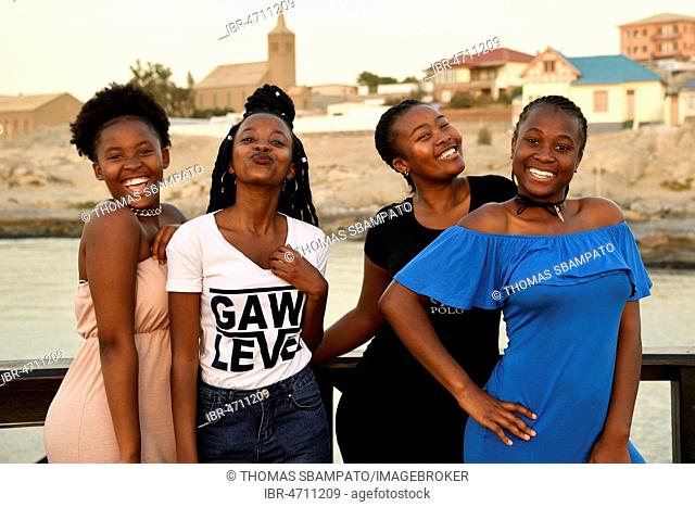 Four young black women posing at the Waterfront, Lüderitz, Namibia