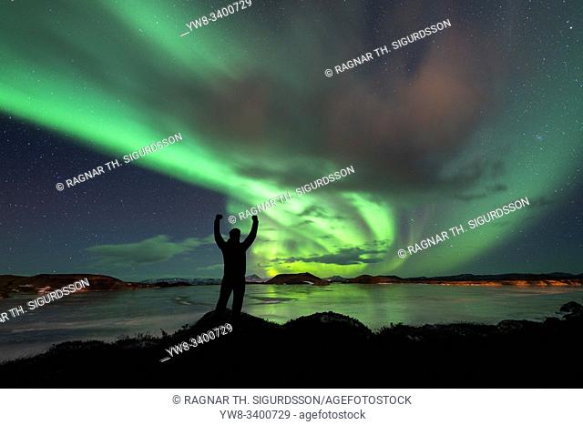 Man with a victory pose, Aurora Borealis, Lake Myvatn, Iceland