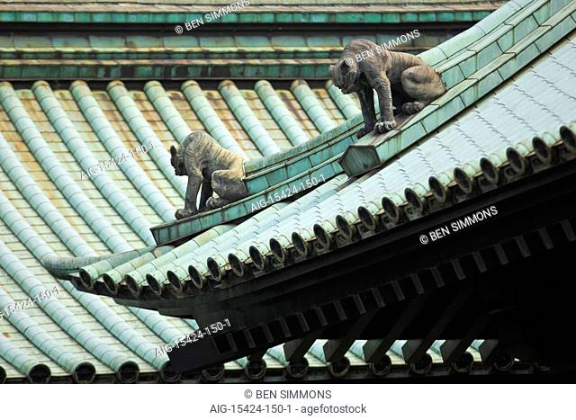 The complex roof design is watched over by komainu lion-dog guardian statues at Yushima-Seido Temple in the old downtown Kanda District of Tokyo, Japan