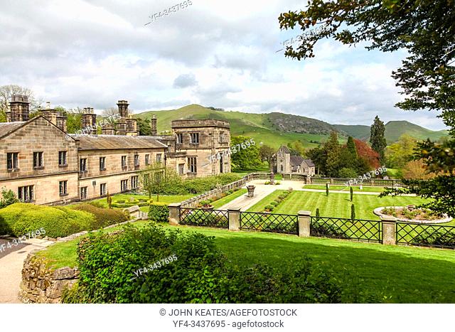 Ilam Hall and gardens with Church Of The Holy Cross in the background, Ilam, Staffordshire, England, UK