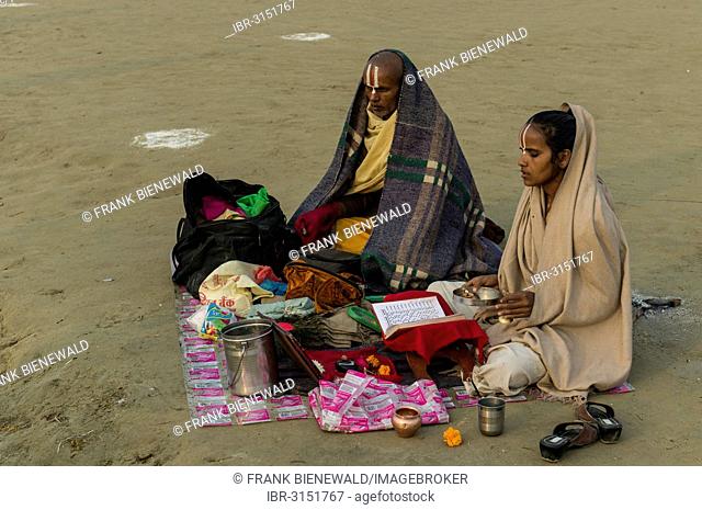 Priest and his daughter meditating, during Kumbha Mela, Allahabad, Uttar Pradesh, India
