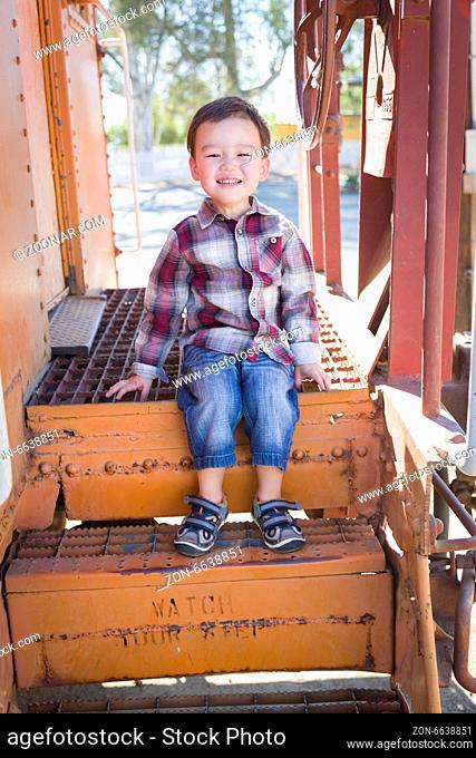 Cute Young Mixed Race Boy Having Fun Outside Sitting on Railroad Car Steps