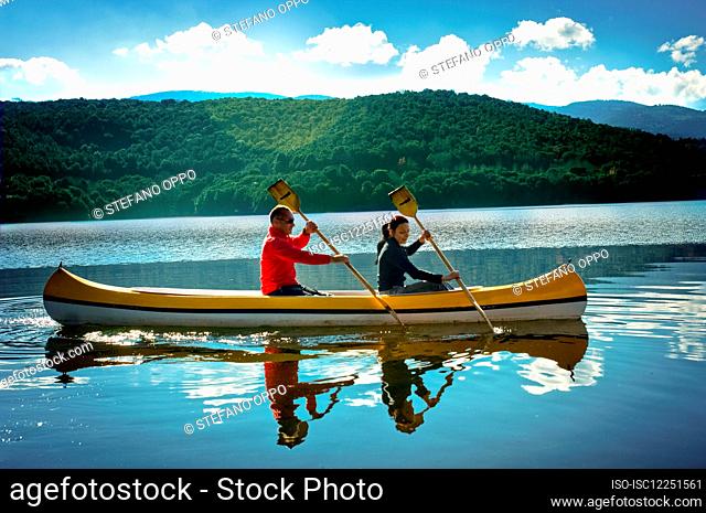 Couple canoeing on Gusana lake, an artificial lake in the territory of Gavoi, Sardinia, Italy
