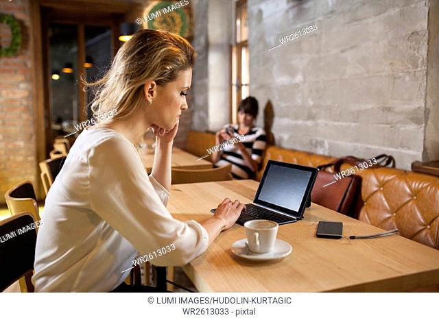 Woman in coffee shop using digital tablet