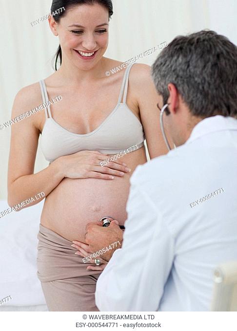 Smiling pregnant woman examined by her gynecologist against a white background