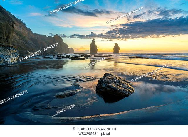 Reflection of the Three Sisters with low tide, at sunset, Tongaporutu, New Plymouth district, Taranaki region, North Island, New Zealand, Pacific