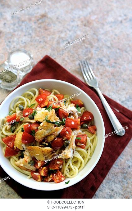 Spaghetti with haddock, tomatoes and capers seen from above