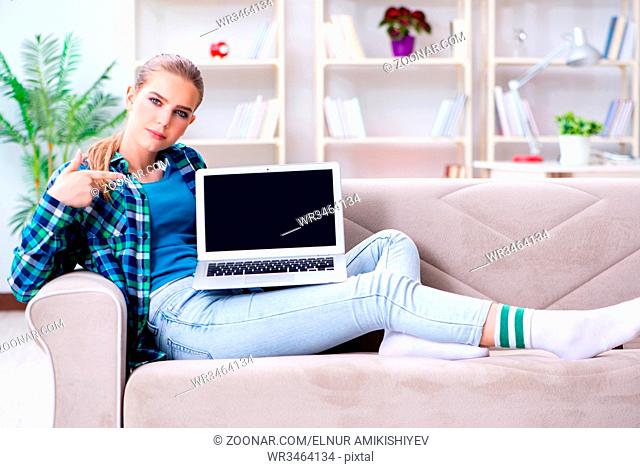 Female student sitting on the sofa with laptop