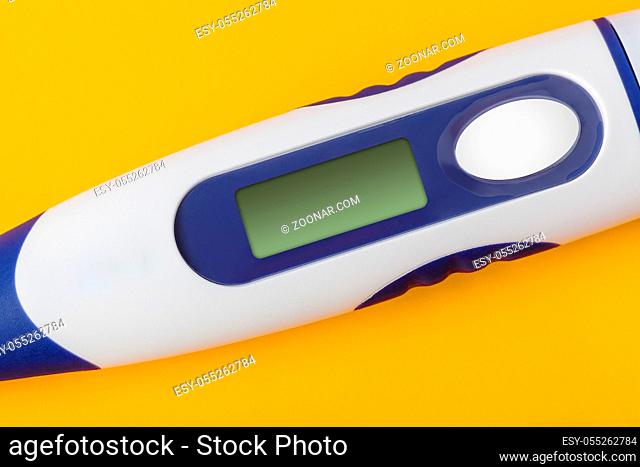 Electronic medical thermometer with blank screen isolated on yellow background