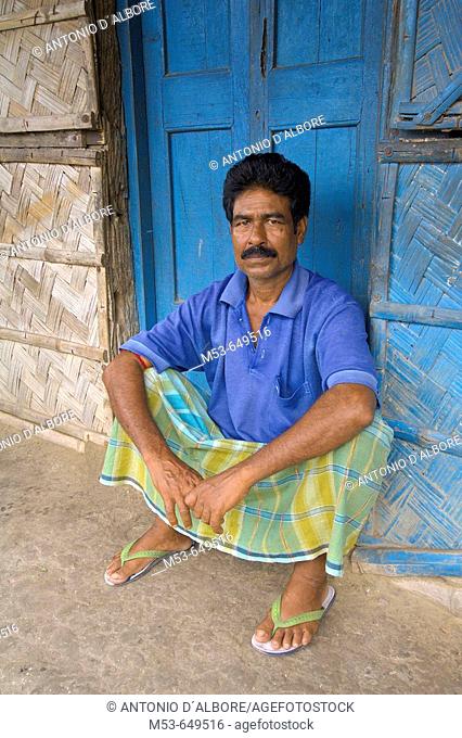 an indian man rest on the doorstep of his home in dhapa district. kolkata. west bengal. india. asia