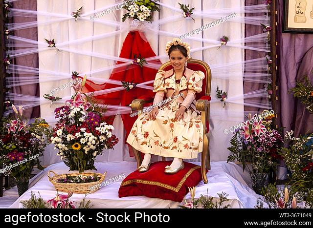 A Maya girl sits in an altar during the traditional celebration of Los Mayos of Madrid, on the streets, girls and flowers in spring, MADRID , SPAIN, EUROPE